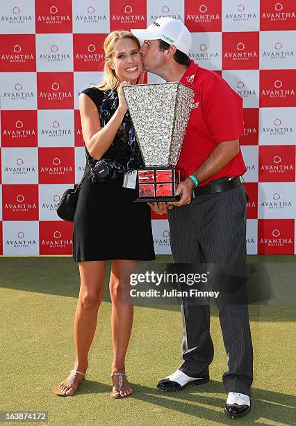 Thomas Aiken of South Africa gives his wife Kate Aiken a kiss as they pose with the winners trophy during day four of the Avantha Masters at Jaypee...