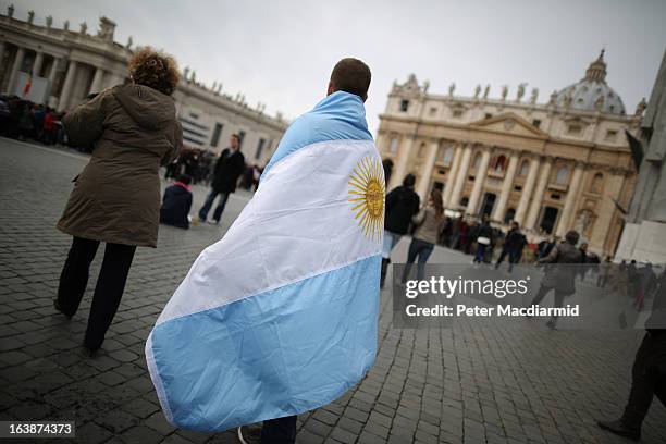 Boy walks in St Peter's Square wrapped in the flag of Argentina before Pope Francis gave his first Angelus blessing on March 17, 2013 in Vatican...