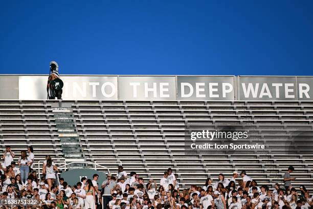 Michigan State fan dressed as a Spartan stands at the top of the upper deck during a college football game between the Michigan State Spartans and...