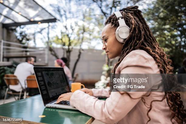 young woman using laptop on a coffee shop - garden office bildbanksfoton och bilder