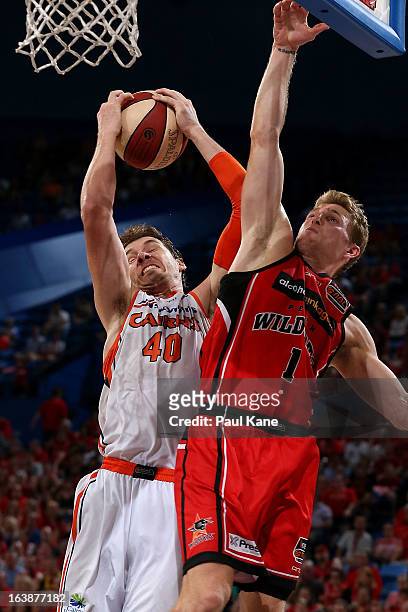 Alex Loughton of the Taipans rebounds against Rhys Carter of the Wildcats during the round 23 NBL match between the Perth Wildcats and the Cairns...