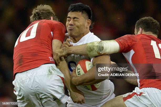 England's centre Manu Tuilagi gets tackled by Wales's fly half Dan Biggar and Wales's centre Jamie Roberts during the Six Nations international rugby...