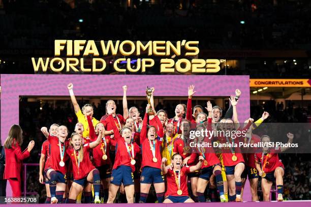 Ivana Andrés of Spain lifts the Women's World Cup trophy and players celebrate the winning of the tournament during the ceremony after the FIFA...