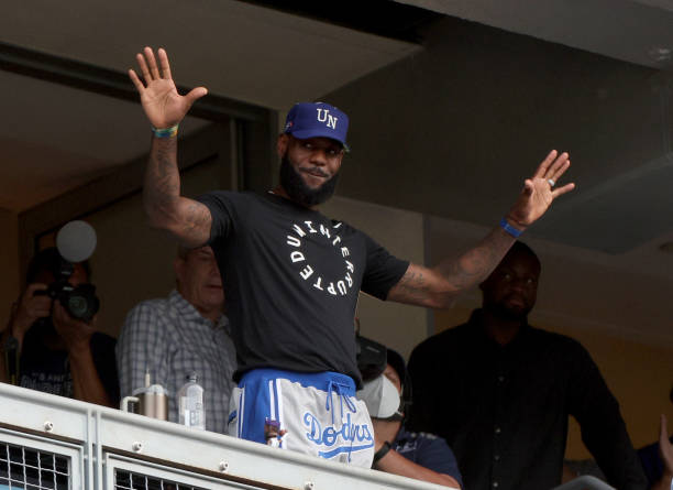 LeBron James of the Los Angeles Lakers waves to the crowd during the game against the Miami Marlins on LeBron James bobblehead night at Dodger...
