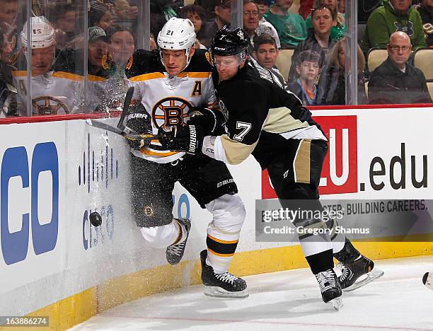 Paul Martin of the Pittsburgh Penguins battles for the loose puck against Andrew Ference of the Boston Bruins on March 17, 2013 at Consol Energy...