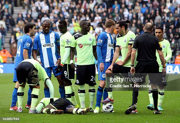 Massadio Haidara of Newcastle United lies injured during the Barclays Premier League match between Wigan Athletic and Newcastle United on March 17,...