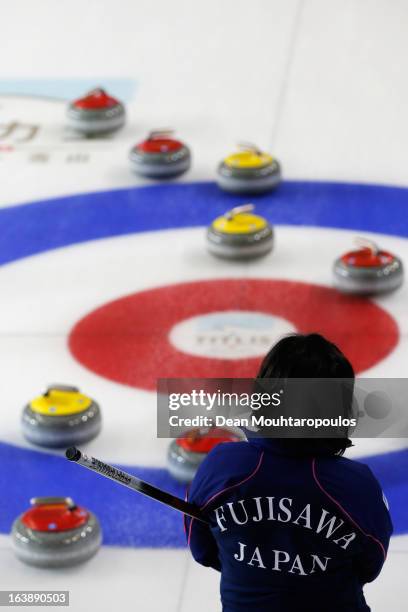 Satsuki Fujisawa of Japan inspects the stones and the play area rings in the match between Japan and Latvia during Day 2 of the Titlis Glacier...