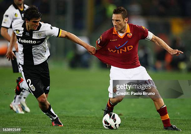 Alvaro Ampuero of Parma FC competes for the ball with Francesco Totti of AS Roma during the Serie A match between AS Roma and Parma FC at Stadio...