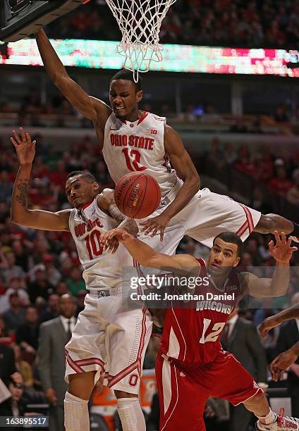 LaQuinton Ross and Sam Thompson of the Ohio State Buckeyes and Traevon Jackson of the Wisconsin Badgers collide while going after a rebound during...