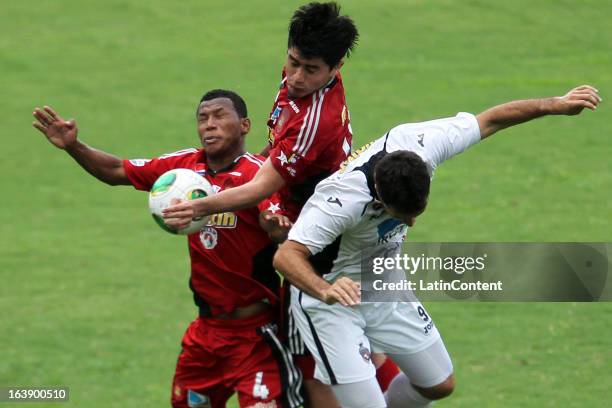 Javier Guarino of Real Esspor fights for the ball with Antonio Da Silva and Andres Sanchez of Caracas FC during the match between Real Esppor Club...