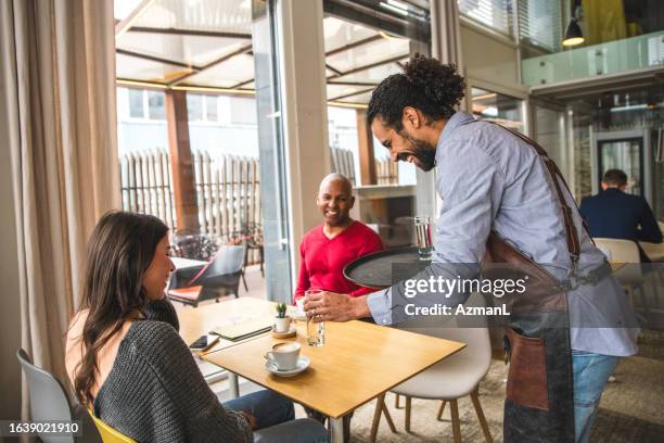 cheerful middle easter waiter serving customers in a cafe - cheesecake white stock pictures, royalty-free photos & images