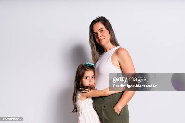 portrait of daughter hugging mother - family portrait serious stock pictures, royalty-free photos & images