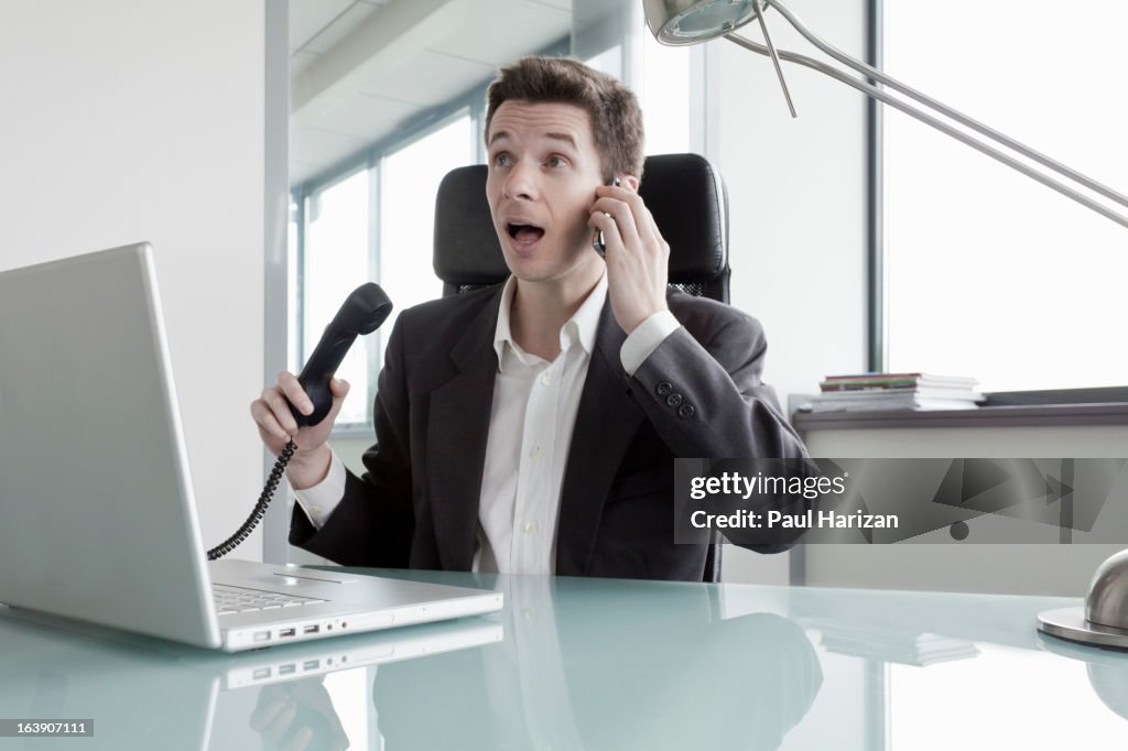 Man with two phones in the office