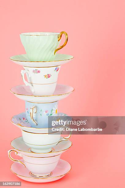 cuatro pretty old fashioned teacups apilar en rosa antigua - taza te fotografías e imágenes de stock