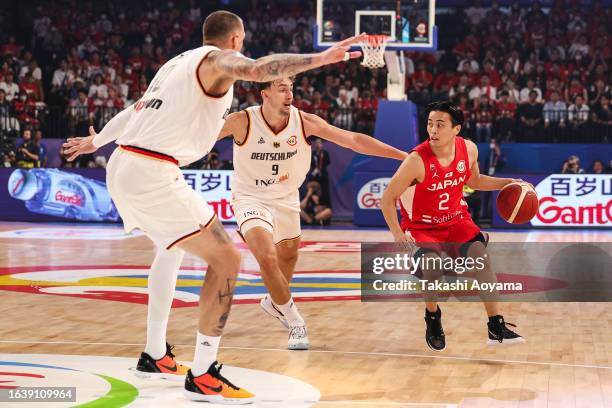 Yuki Togashi of Japan drives to the basket against Franz Wagner and Daniel Theis of Germany during the FIBA World Cup Group E game between Germany...