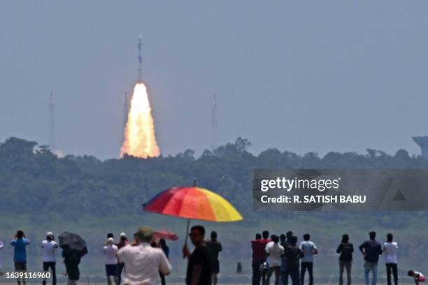 People watch as the PSLV XL rocket carrying the Aditya-L1 spacecraft, the first space-based Indian observatory to study the Sun, is launched from the...