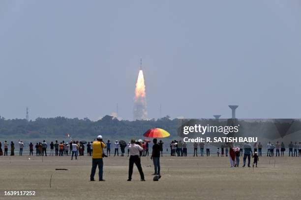 People watch as the PSLV XL rocket carrying the Aditya-L1 spacecraft, the first space-based Indian observatory to study the Sun, is launched from the...