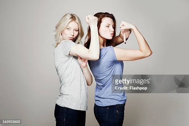 studio portrait of two women who are best friends - frauenpower stock-fotos und bilder