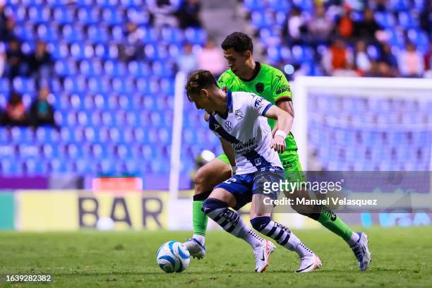 Facundo Waller of Puebla battles for the ball against Christian Oliva of Juarez FC during the 6th round match between Puebla and FC Juarez as part of...