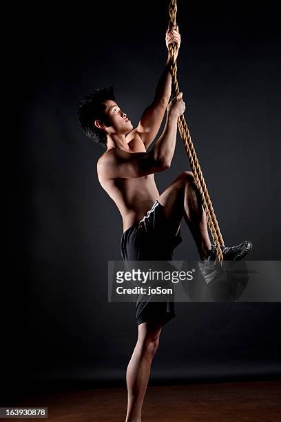 athlete doing exercises - male athlete with rope on black background stock pictures, royalty-free photos & images