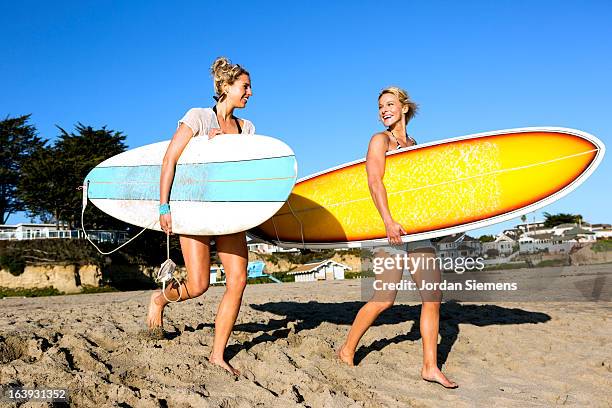two females surfing. - ボード　持つ　女性 ストックフォトと画像