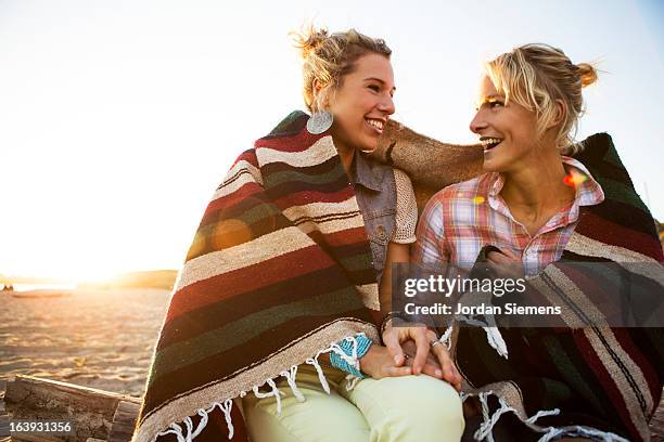 friends enjoying a beach bonfire. - woman in a shawl stockfoto's en -beelden
