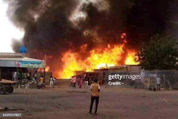 Man stands by as a fire rages in a livestock market area in al-Fasher, the capital of Sudan's North Darfur state, on September 1 in the aftermath of...