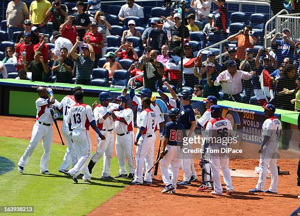 Carlos Santana of Team Dominican Republic celebrates with teammates after hitting a solo home run in the bottom of the fifth inning during Pool 2,...
