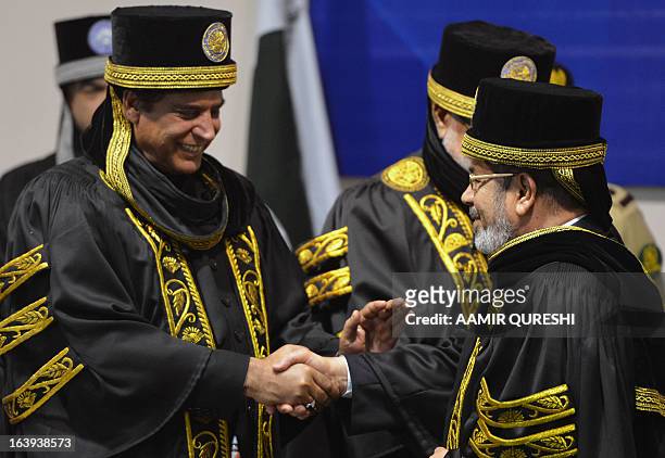 Egyptian President Mohamed Morsi shakes hands with Pakistan's Prime Minister Raja Pervez Ashraf after he was conferred with an honourary doctor of...