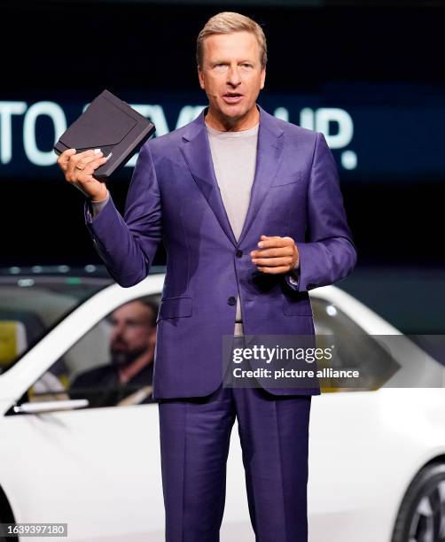 September 2023, Bavaria, Munich: BMW CEO Oliver Zipse holds the vehicle's control system during the presentation of the new BMW "New Class" at an...