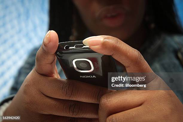 Customer inspects a new Nokia Asha 311 smartphone during a promotional "activation day" event by Nokia Oyj in Maponya Mall in Soweto, South Africa,...