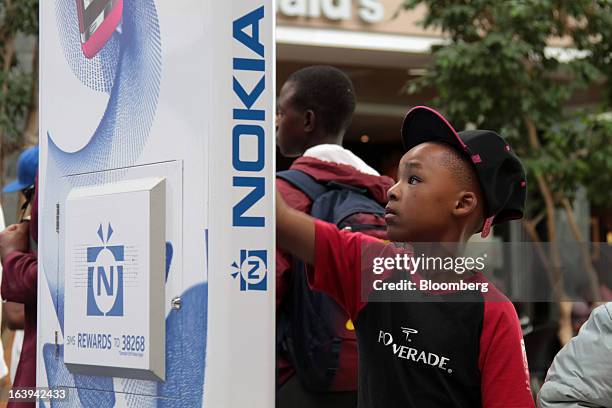 Child interacts with a touch screen during a promotional event for Asha smartphones by Nokia Oyj in Maponya Mall in Soweto, South Africa, on...