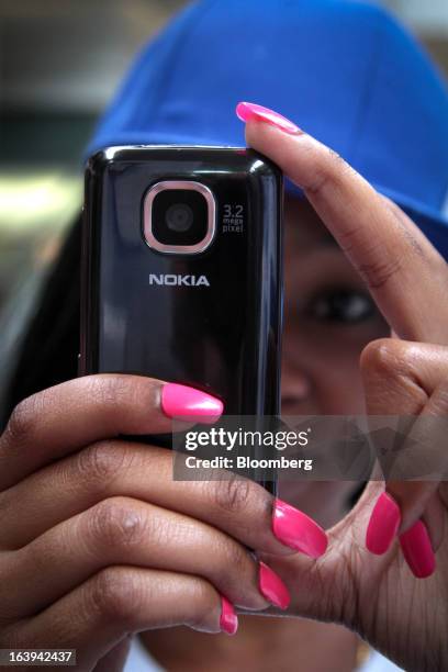 An employee demonstrates the use of a new Nokia Asha 311 smartphone during a promotional "activation day" event by Nokia Oyj in Maponya Mall in...