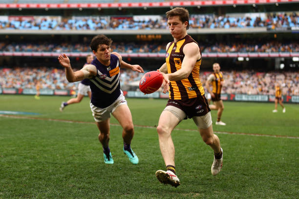 Josh Ward of the Hawks kicks under pressure from Lachie Schultz of the Dockers during the round 24 AFL match between Hawthorn Hawks and Fremantle...