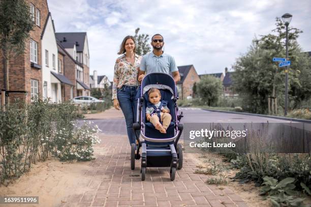 modern fatherhood outdoor lifestyle in the neighbourhood for diverse family - kinderwagen stockfoto's en -beelden