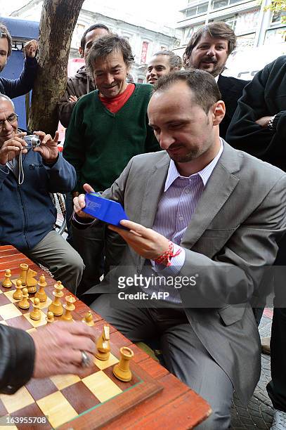 Bulgarian chess grandmaster Veselin Topalov looks at a chess timer before playing a chess match against Uruguayan Carlos Ferrari , near to a...
