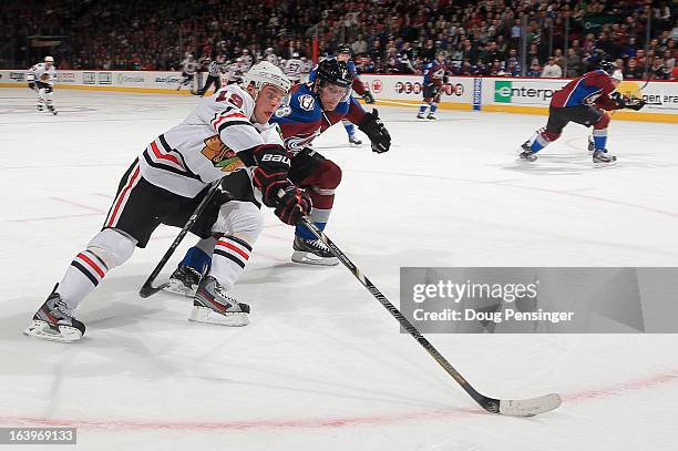 Jonathan Toews of the Chicago Blackhawks controls the puck against Jan Hejda of the Colorado Avalanche at the Pepsi Center on March 18, 2013 in...