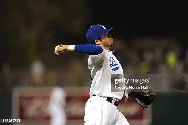 Alfredo Amezaga of the Los Angeles Dodgers throws the ball to first base against the Kansas City Royals on March 15, 2013 in Glendale, Arizona.