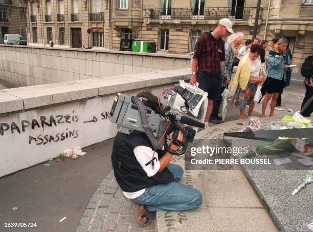 Un cameraman filme, le 1er septembre, l'endroit marqué de graffiti dénonçant les paparazzi, au-dessus du tunnel du pont de l'Alma à Paris où fleurs...