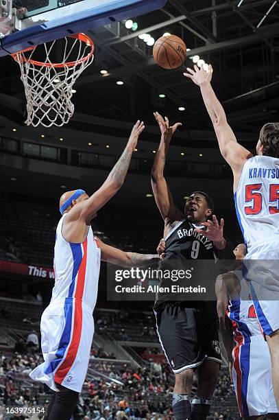 MarShon Brooks of the Brooklyn Nets shoots against Charlie Villanueva and Viacheslav Kravtsov of the Detroit Pistons on March 18, 2013 at The Palace...