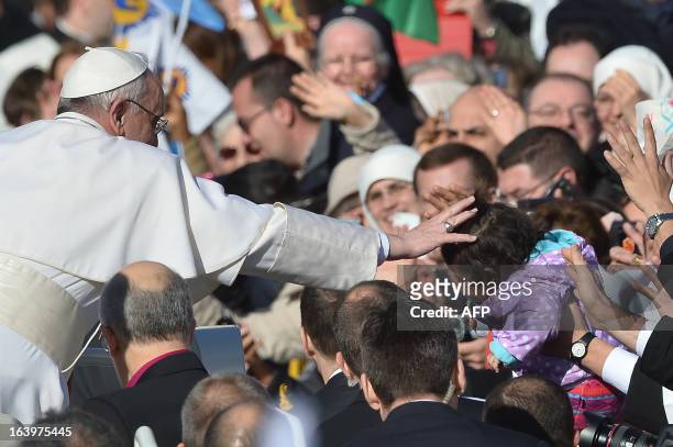 Pope Francis blesses a little girl in the crowd from the papamobile during his inauguration mass at St Peter's square on March 19, 2013 at the...