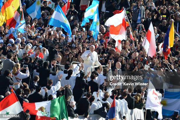 Pope Francis waves as he arrives in the papamobile on St Peter's square for his grandiose inauguration mass on March 19, 2013 at the Vatican. The...