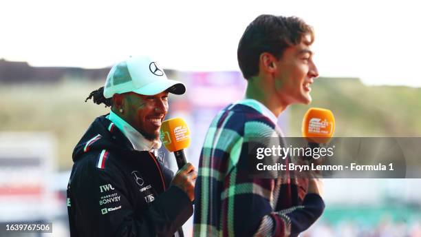 Lewis Hamilton of Great Britain and Mercedes and George Russell of Great Britain and Mercedes talk to the crowd on the fan stage prior to final...