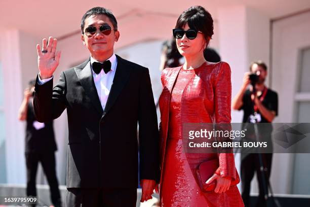 Hong Kong actor Tony Leung Chiu-wai poses with his wife Carina Lau Kar-ling on the red carpet for the Golden Lion for Lifetime Achievement award at...