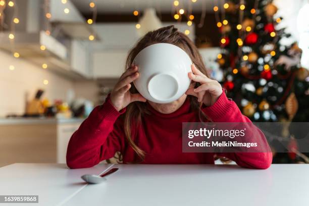 girl eating breeakfast on christmas morning - christmas breakfast stock pictures, royalty-free photos & images