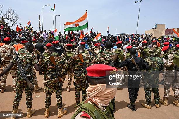 Nigerien soldiers stand guard as supporters of Niger's National Council of Safeguard of the Homeland protest outside the Niger and French airbase in...