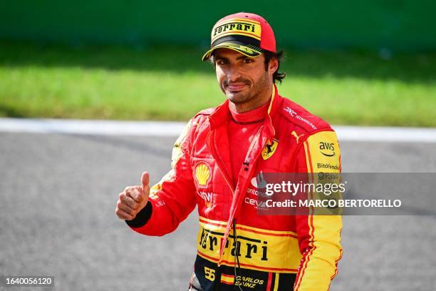 First placed Ferrari's Spanish driver Carlos Sainz Jr gestures a thumbs-up after scoring pole position in the qualifying session, ahead of the...