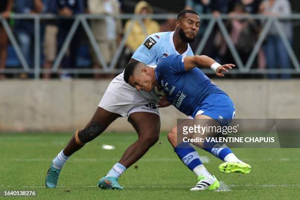 Bayonne's French fullback Cheikh Tiberghien fights is tackled by Castres' French centre Adrien Seguret during the French L1 football match between...