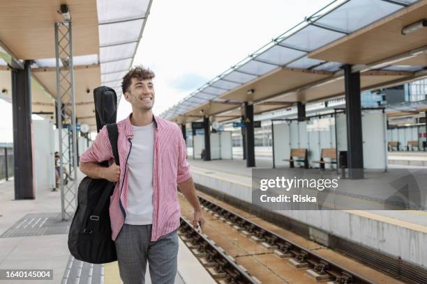 young musician waiting for a train - passenger musician stock pictures, royalty-free photos & images