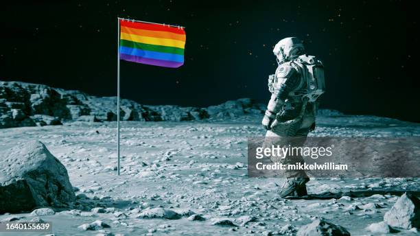 rainbow colored flag is planted on the surface of a planet or moon - flag stock pictures, royalty-free photos & images